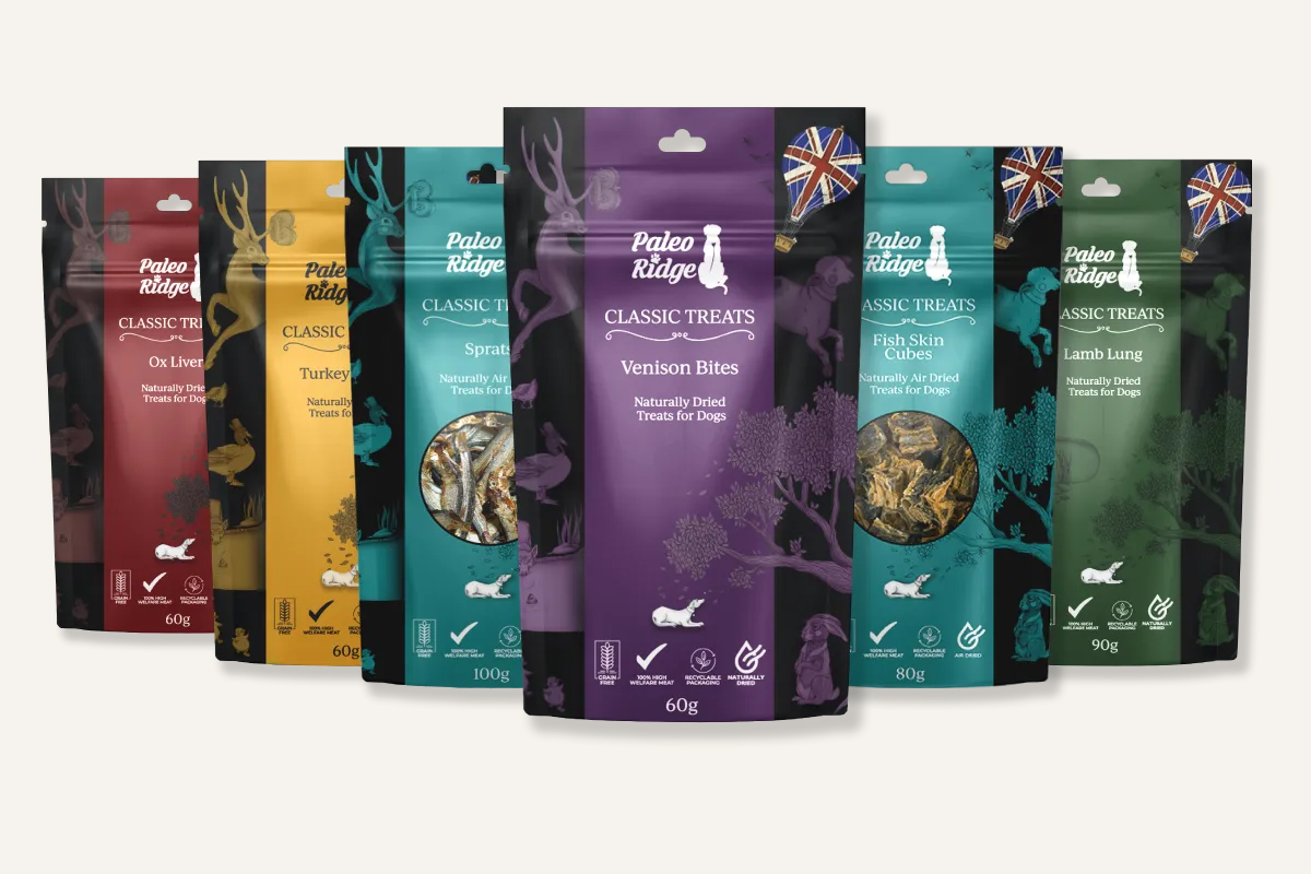 Five packages of Paleo Ridge Classic Treats for dogs, each featuring different flavors: Ox Liver, Turkey, Sprats, Venison Bites, and Fish Skin Cubes, with color-coded designs and images of each treat on the front.